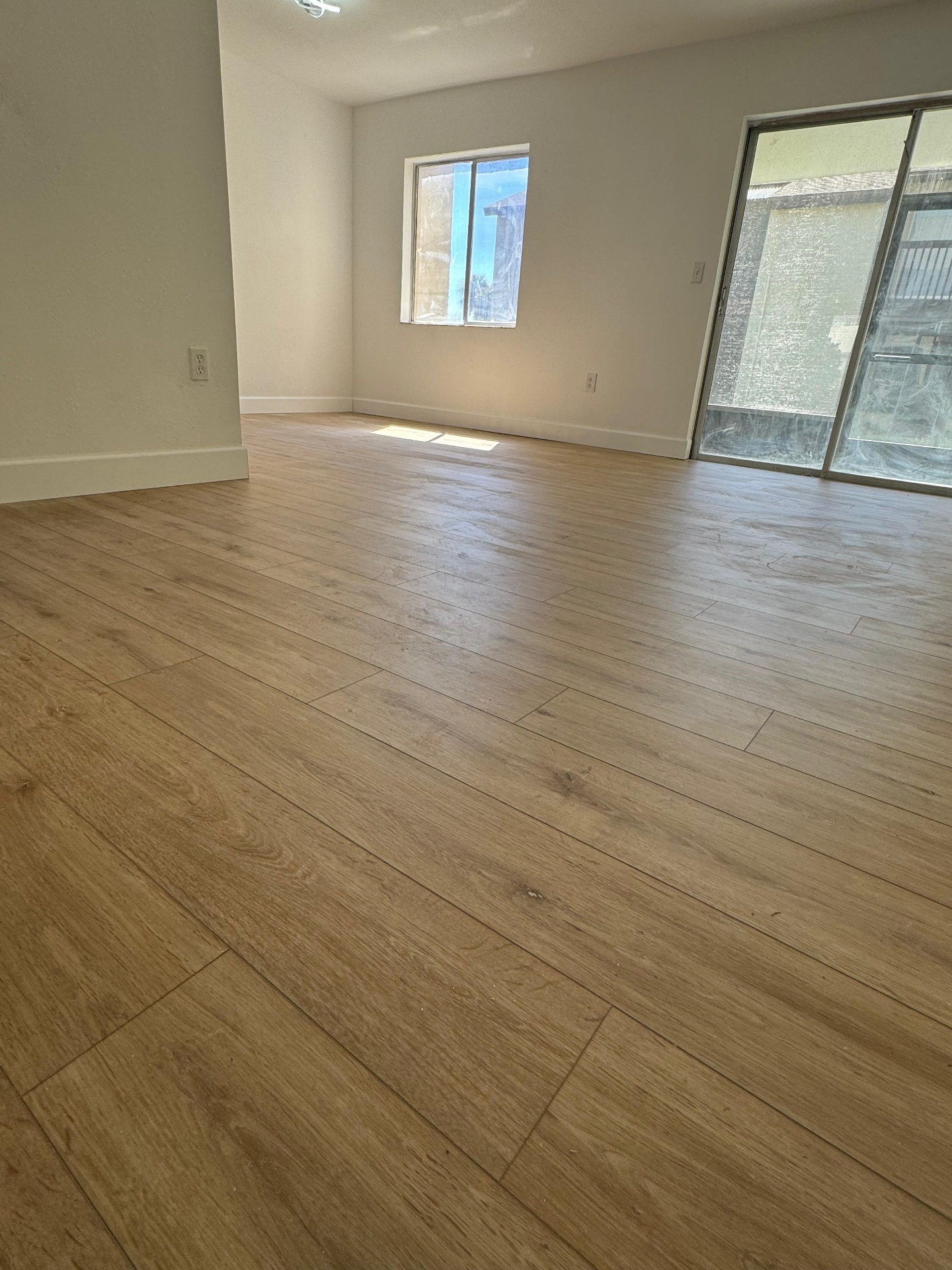 Herringbone hardwood floor in a sunlit gallery